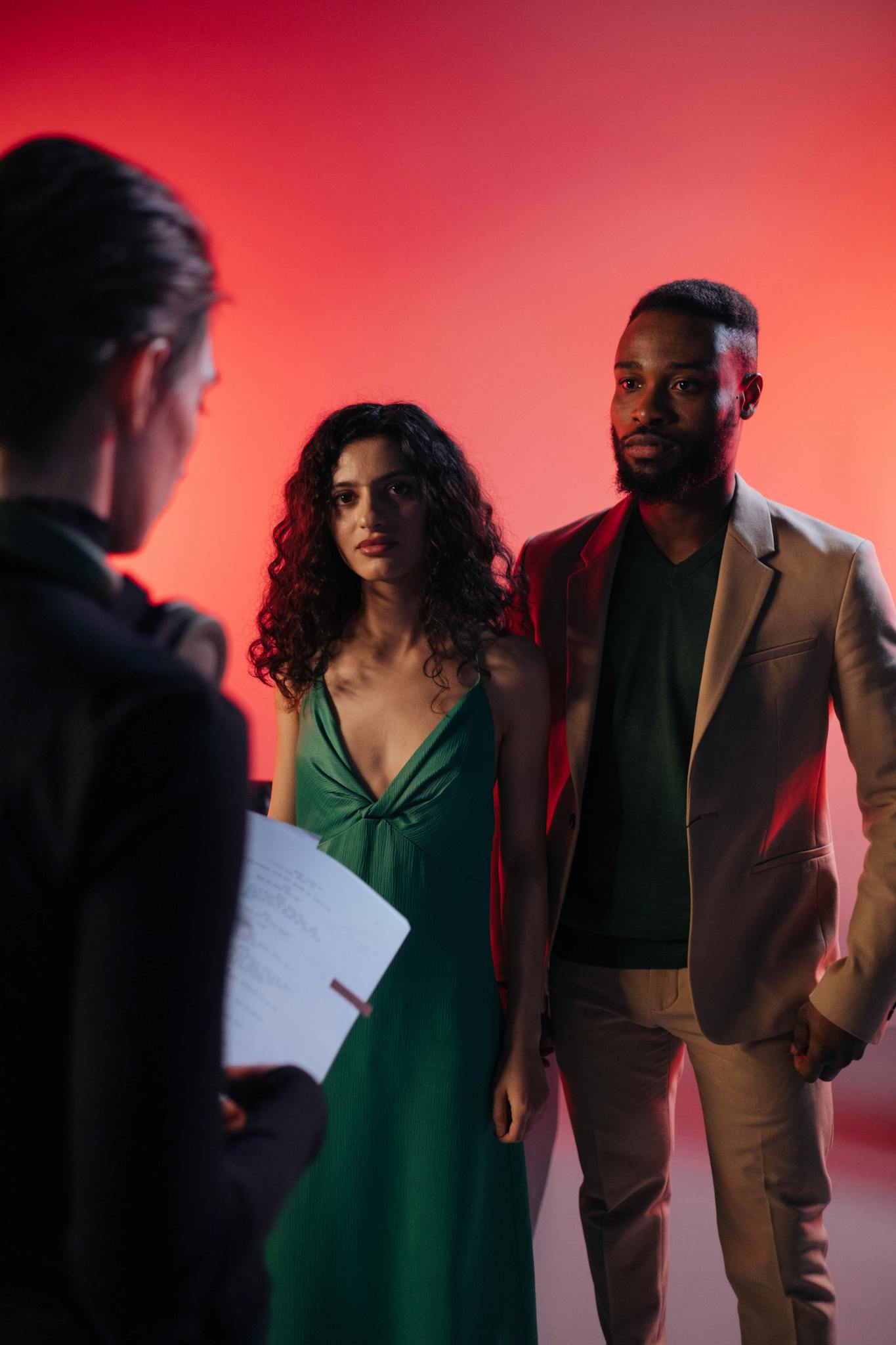 Actors rehearsing with a director in a studio setting, discussing the script and roles.